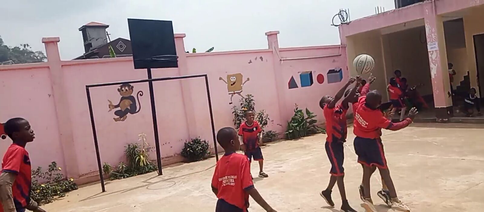 Élèves jouant au basketball dans la cour